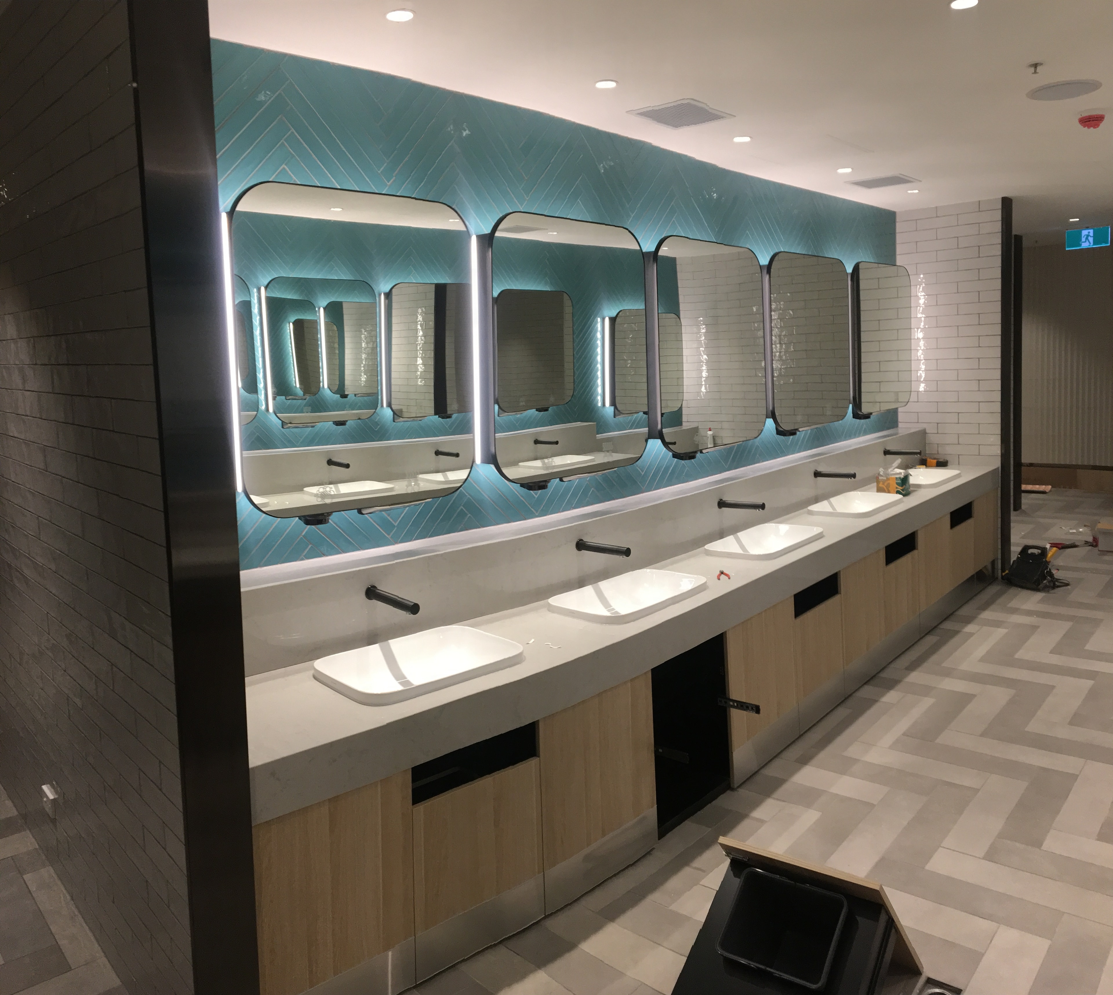 Shopping centre amenities — teal herringbone tile feature wall